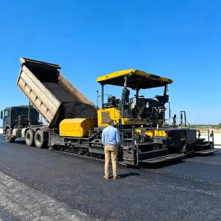 Paving customer lead beside asphalt paver and MTV