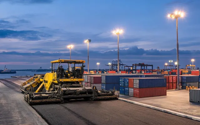 Port yard asphalt paving beside container stacks